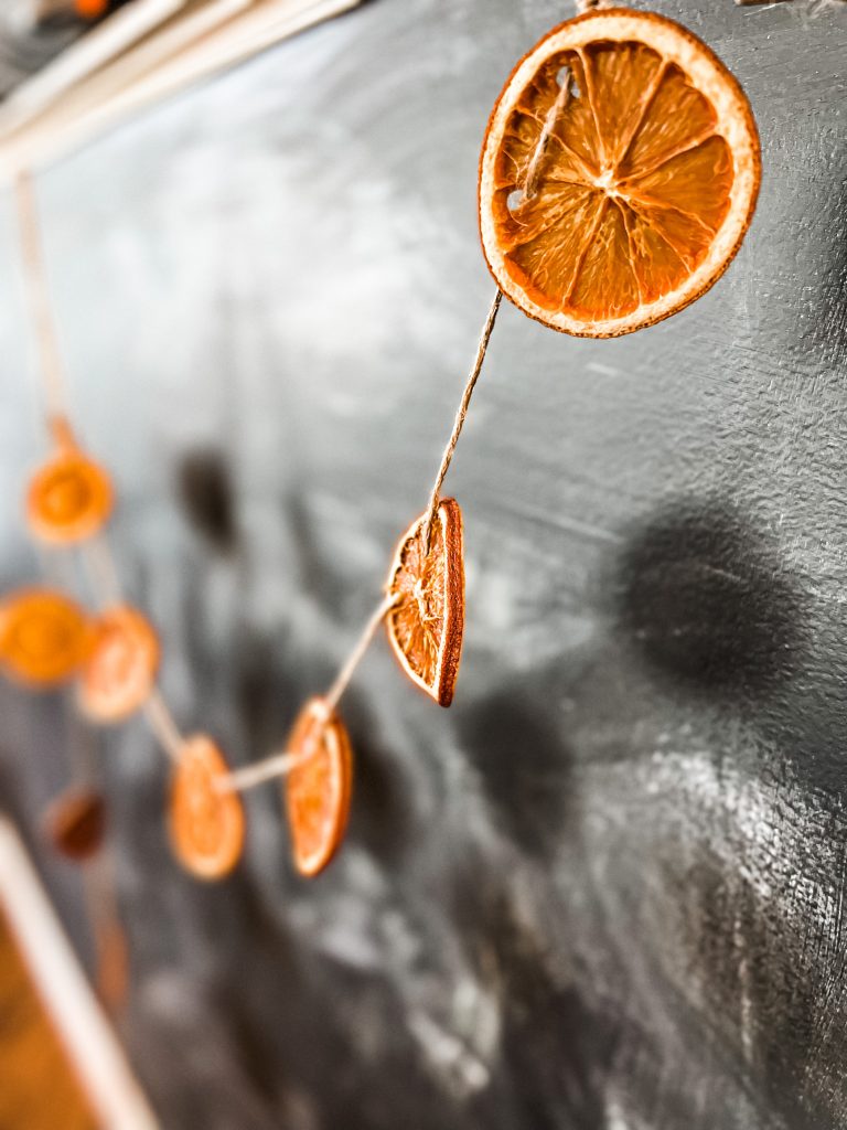 dried oranges against a chalk board wall