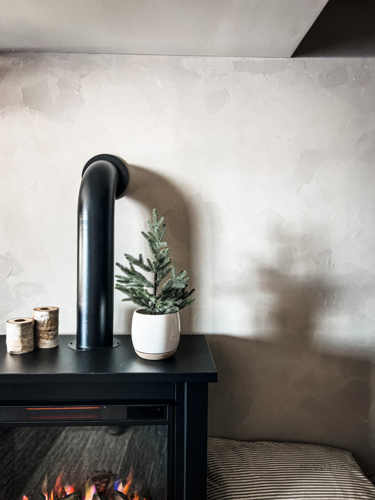 black fireplace against roman clay wall