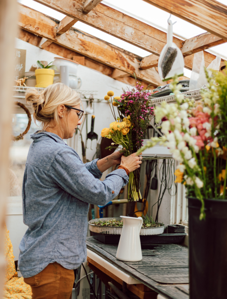 flower farmer placing fresh flowers into vase