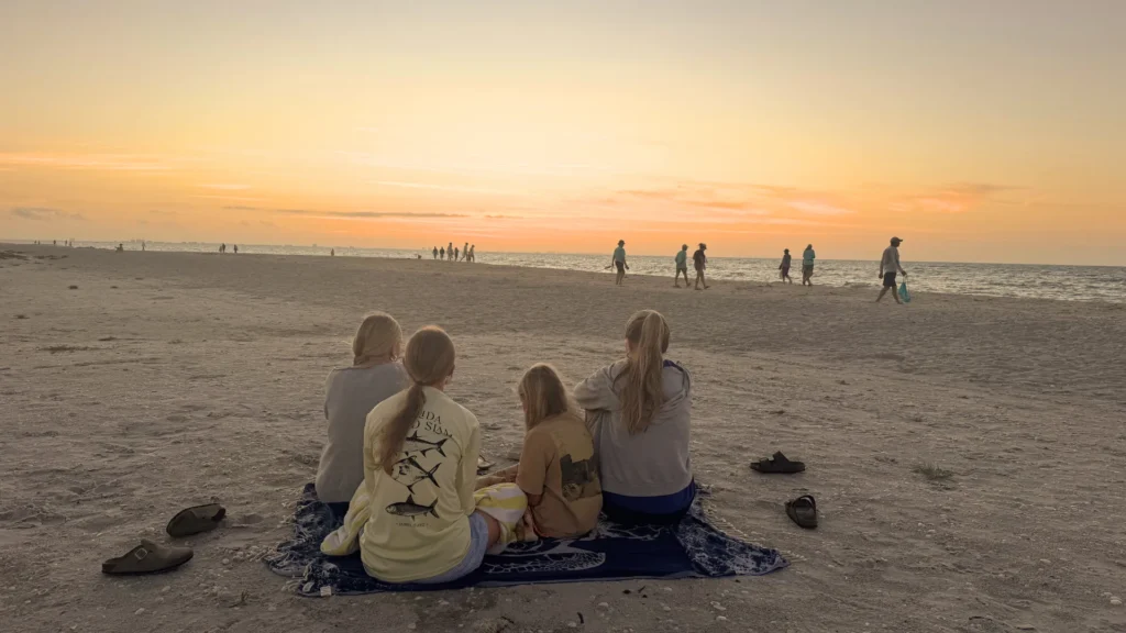 family on a beach at sunset